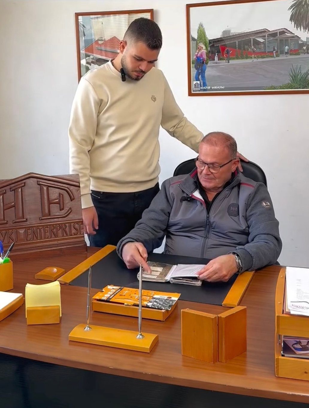 Two generations of the Hrayki family reviewing project drawings
